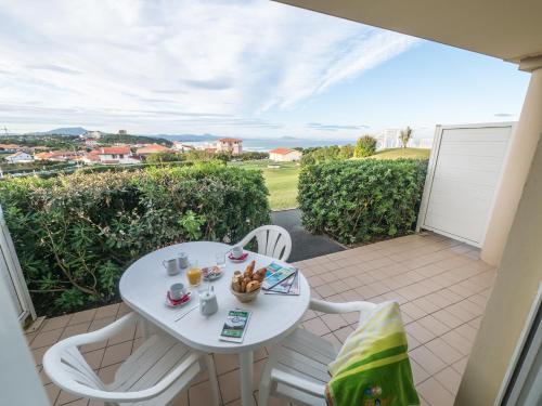 a small white table and chairs on a balcony at Résidence Mer & Golf Eugénie in Biarritz