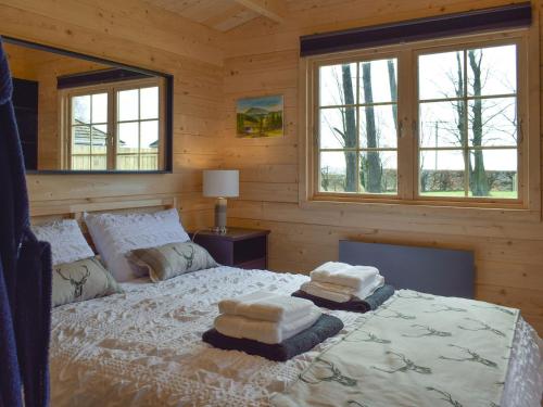 a bedroom with a bed with two towels on it at Pinewood Cabin in Saline