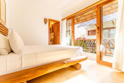 a bedroom with a bed and a balcony at CasaLô Hotel in Jericoacoara