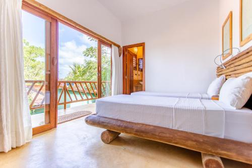 a bedroom with two beds and a balcony at CasaLô Hotel in Jericoacoara