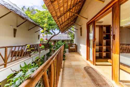 a balcony with a wooden railing and plants at CasaLô Hotel in Jericoacoara