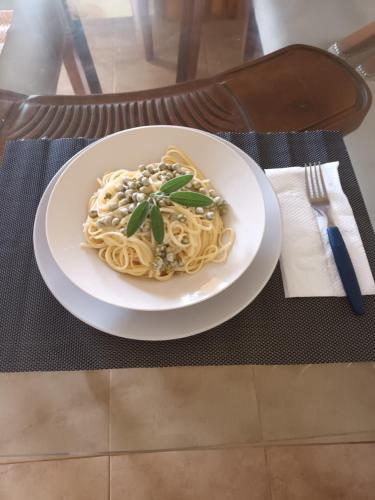 a plate of pasta on a table with a fork at Casa taina in Jarabacoa
