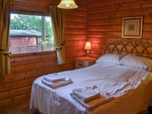 a bedroom with a bed in a log cabin at Ludensian Lodge - Uk37186 in Legbourne