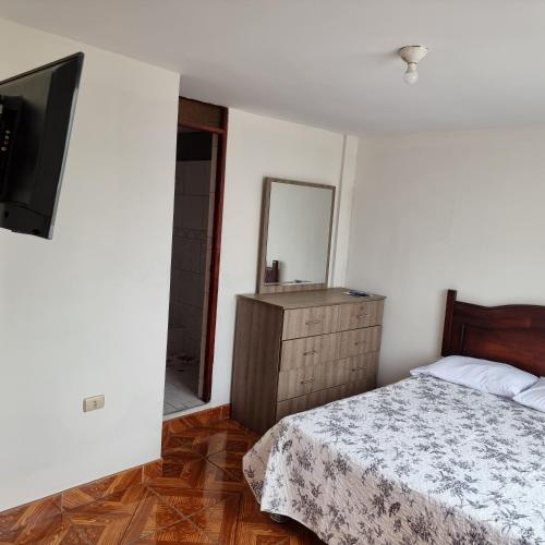 1 dormitorio con cama, tocador y espejo en Apart Hotel Cabral, en Lima