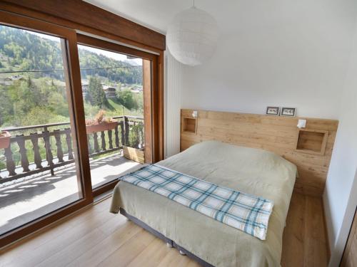 une chambre avec un lit et une grande fenêtre dans l'établissement Magnifique T5 rénové 10 pers, lumineux à Morzine - FR-1-684-23, à Morzine