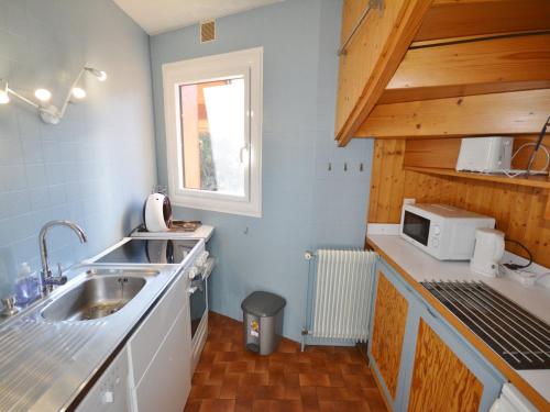 une petite cuisine avec un évier et un micro-ondes dans l'établissement **Duplex 6 pers. au centre de Morzine, proche pistes et remontées mécaniques** - FR-1-684-32, à Morzine