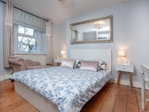 Schlafzimmer mit einem Bett und einem Wandspiegel in der Unterkunft Bird Box in Brixham