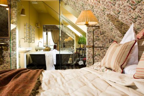 a bedroom with a bed and a sink and a mirror at Apvalaus Stalo Klubas Gastro & SPA Hotel in Trakai