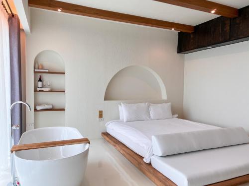 a bedroom with a bed and a bath tub at Inlaya Ratchaburi in Ratchaburi