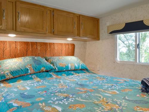 a bed with a blue comforter in a bedroom at Goose View in Montrose