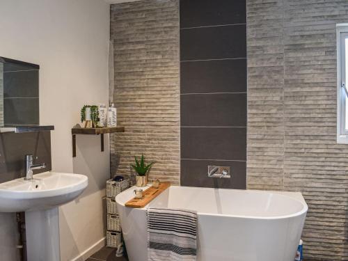 a bathroom with a white tub and a sink at Britannic Chambers Apartment in Blaenau-Ffestiniog