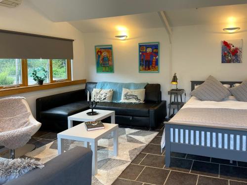 ein Wohnzimmer mit 2 Betten und einem Sofa in der Unterkunft The Lodge At The Lake House in Ifold