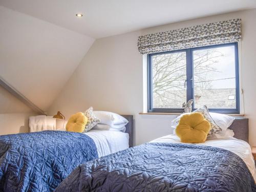 two beds in a room with a window at Box Tree Barn in Hampton Bishop