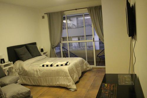 Schlafzimmer mit einem Bett und einem Fenster in der Unterkunft AA Naon apart in Buenos Aires