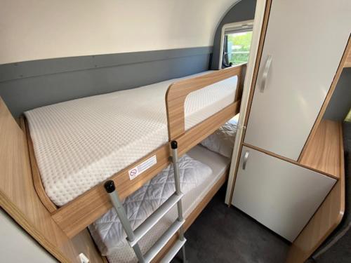 Mały pokój z łóżkiem piętrowym w pokoju typu rv w obiekcie Wohnwagenvermietung CAMPING-SYLT / Morsum w mieście Westerwall