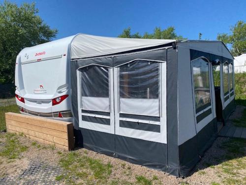 a black and white tent next to a truck at Wohnwagenvermietung CAMPING-SYLT / Morsum in Westerwall