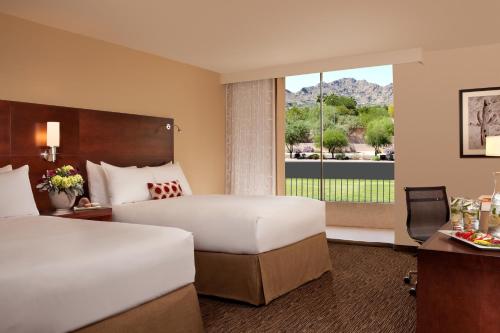 a hotel room with two beds and a window at The McCormick Scottsdale in Scottsdale