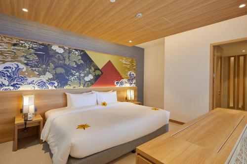 a bedroom with a large bed and a large painting on the wall at Da Nang - Mikazuki Japanese Resorts & Spa in Da Nang