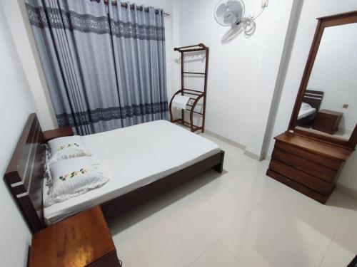 a small bedroom with a bed and a mirror at Onara Guest in Anuradhapura