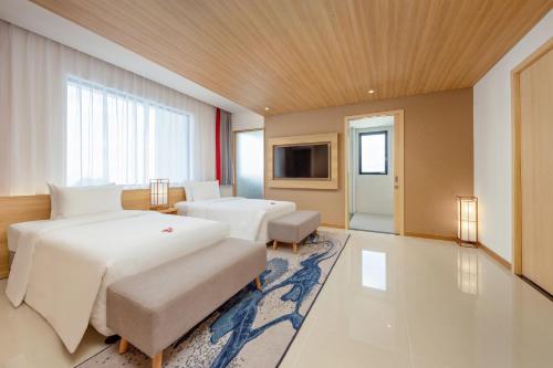 a hotel room with two beds and a television at Da Nang - Mikazuki Japanese Resorts & Spa in Da Nang