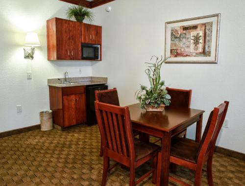 a kitchen with a table and chairs and a kitchen with a sink at Spring Lake Inn & Suites - Fayetteville in Spring Lake