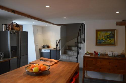 a kitchen with a bowl of fruit on a wooden table at La Souqueto in Mirepeisset