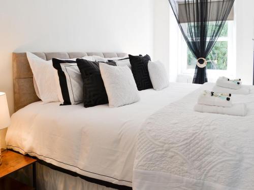 a bedroom with a large white bed with black and white pillows at Merrick - Uk34536 in Newton Stewart