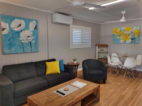 ein Wohnzimmer mit einem Sofa und einem Tisch in der Unterkunft Cute City Cottage - 2 Bedroom - The Strand in Townsville