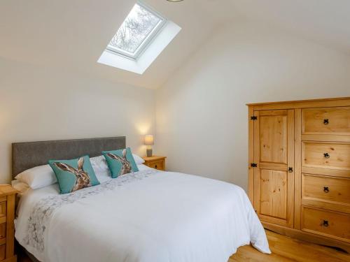 a bedroom with a white bed and a skylight at Heath Barn in Suckley