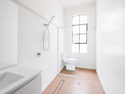 a white bathroom with a toilet and a window at Historic Pub Accommodation- En-suites - Shared Bathroom Double Rooms - Shared Bathroom Twins in Portland