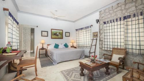 a bedroom with a bed and a table in a room at Korta Escape- A Heritage Resort in Jawai in Korta