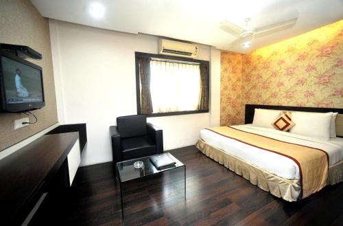 a hotel room with a bed and a television at Hotel Lee International in Kolkata