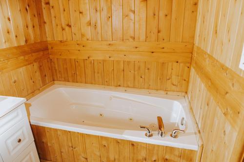 a bath tub in a wood paneled bathroom at Lang Lake Resort in Espanola