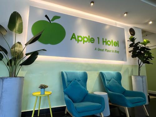 een bord voor een appelhotel met blauwe stoelen bij Apple 1 Hotel Queensbay in Bayan Lepas