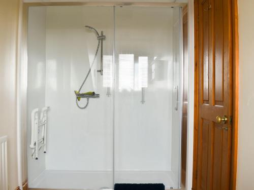 a shower with a glass door in a bathroom at Maverhurst in Earnley