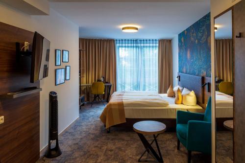 une chambre d'hôtel avec un lit et une chaise dans l'établissement Trip Inn City Hotel Giessen, à Giessen