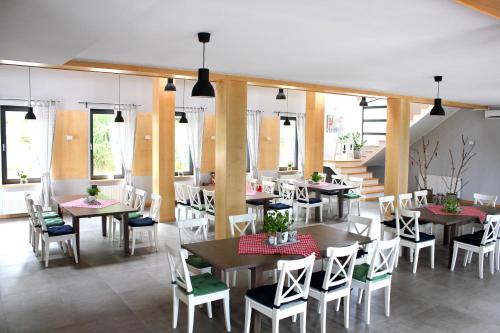 a dining room with tables and chairs and windows at Hotel Chojnik in Podgórzyn