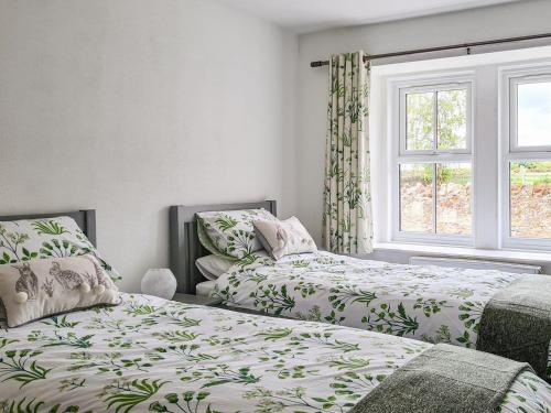 a bedroom with two beds and a window at 2 Setonhill Cottages in Longniddry