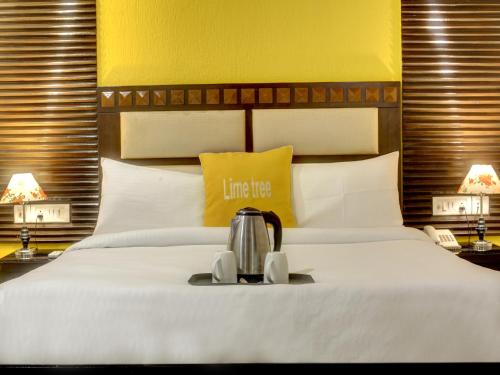 a hotel room with a bed with a tea kettle on it at Lime Stays B&B GK-2 at Greater Kailash Metro South Delhi nearby Saket Select City in New Delhi