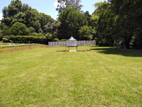 a large field with a gazebo in the middle at Mount Shekinah Country Hotel in Balgowan