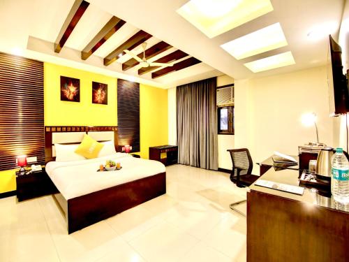 um quarto de hotel com uma cama e uma secretária em The Lime Stays Greater Kailash Metro nearby Saket Select City em Nova Deli