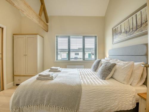sypialnia z łóżkiem z białą pościelą i oknem w obiekcie The Oak w mieście Wingfield