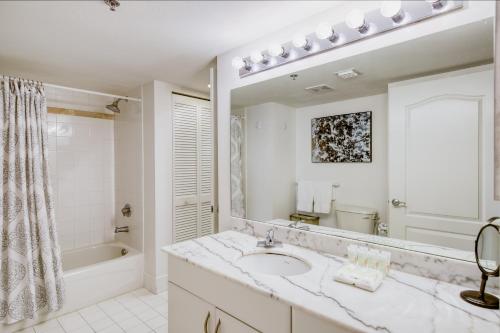 a white bathroom with a sink and a bath tub at Brickell Beauty in Miami
