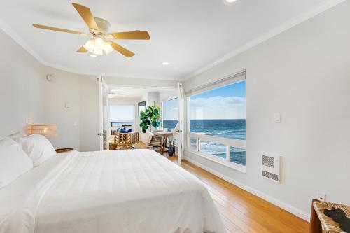 1 dormitorio con cama blanca y ventana grande en Buccaneer Beach Duo, en Oceanside