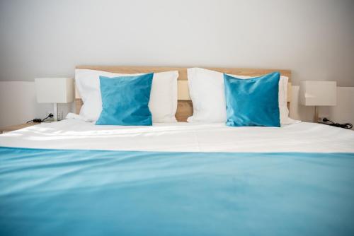 a bed with blue and white pillows on it at Pensiunea Black Mountain in Baia-Sprie