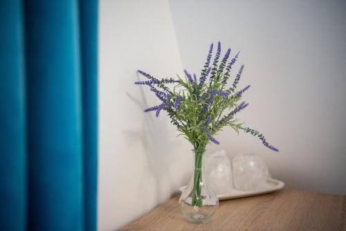 a vase with purple flowers in it on a table at Pensiunea Black Mountain in Baia-Sprie