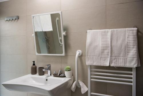 a bathroom with a sink and a mirror and towels at Pensiunea Black Mountain in Baia-Sprie