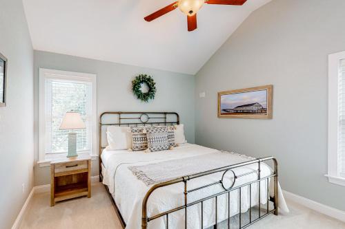 um quarto com uma cama e uma ventoinha de tecto em Coastal Serenity - Unit A - Top Floor em Kill Devil Hills