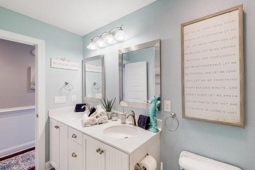 a bathroom with a sink and a mirror at Coastal Serenity - Unit A - Top Floor in Kill Devil Hills