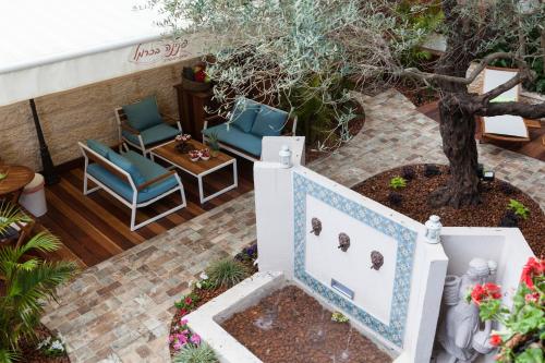 a patio with two chairs and a tree at Carmel Pearl in Haifa